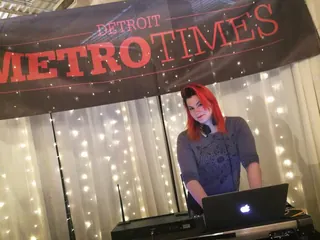 DJ Selina Style spinning a brunch set under a Metro Times banner